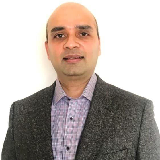 Balaji Nageswaran in a grey blazer and checked shirt.