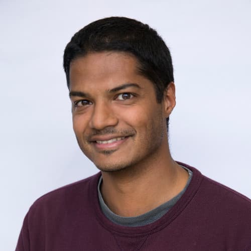 Leonard Picardo smiling in a maroon crewneck.